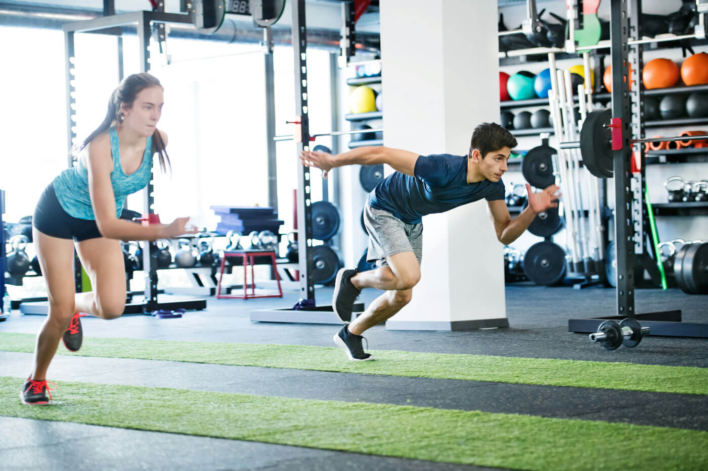 Two people sprinting in a gym