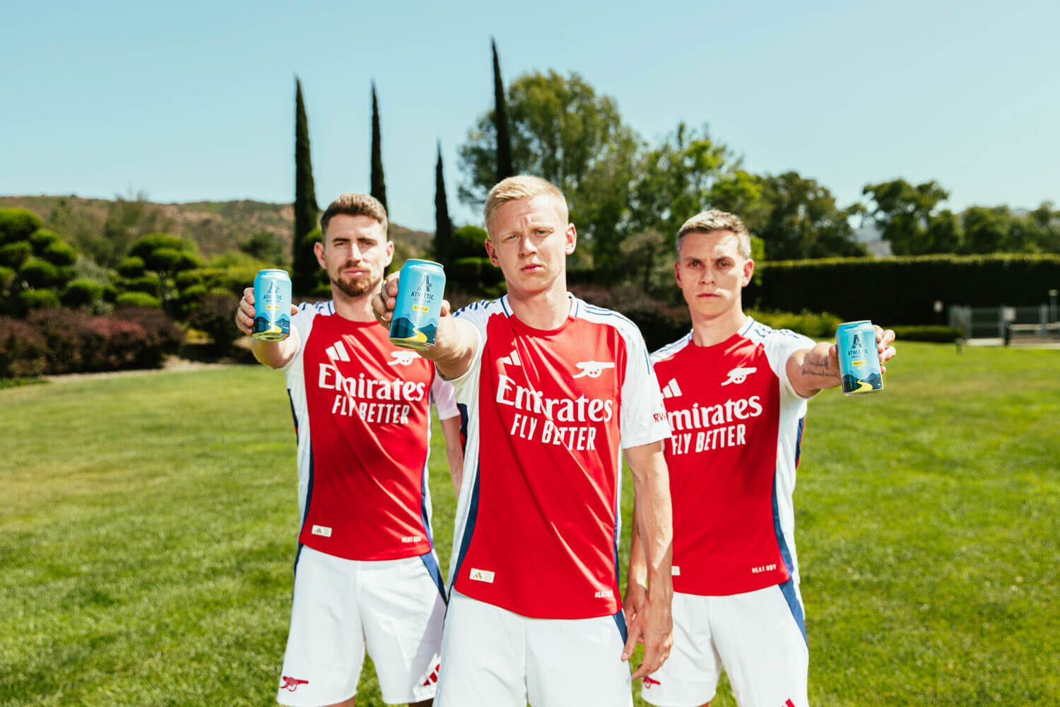 Arsenal football players holding Athletic Brewing cans